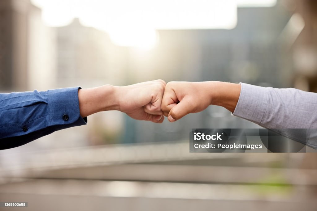 Shot of two unrecognizable businesspeople fist bumping against a city background This will be a great partnership Achievement Stock Photo