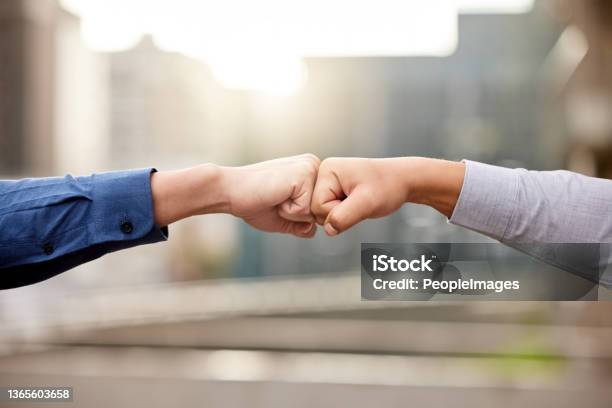 Shot Of Two Unrecognizable Businesspeople Fist Bumping Against A City Background Stock Photo - Download Image Now