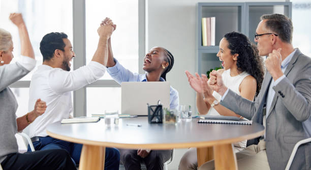 scatto di un gruppo di uomini d'affari che applaudono mentre lavorano in un ufficio - excitement business person ecstatic passion foto e immagini stock