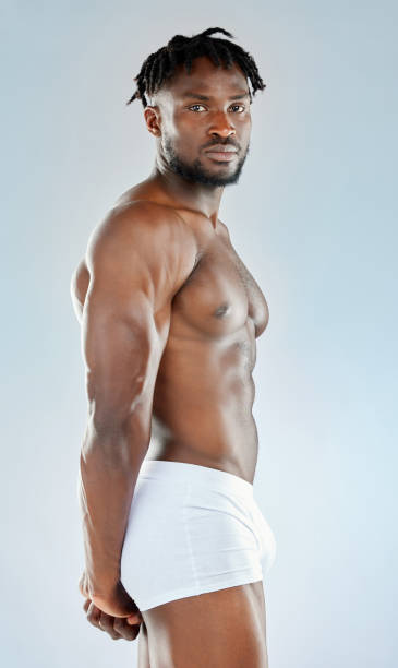 istock Studio shot of a handsome young man flexing his muscles 1365604350
