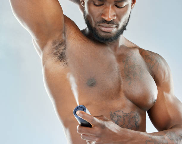 istock Studio shot of a muscular young man spraying himself with deodorant 1365604352