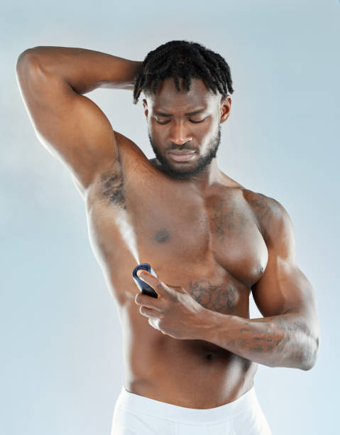 istock Studio shot of a muscular young man spraying himself with deodorant 1365604359