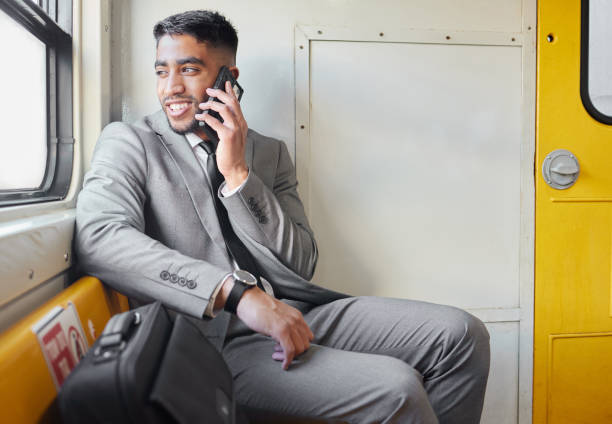 istock Shot of a young businessman talking on a cellphone while staring out the window on a train during his commute 1365605849