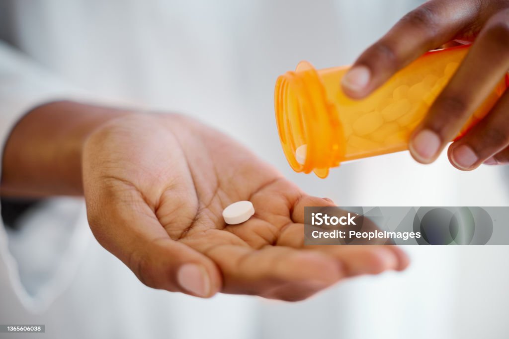 Shot of an unrecognizable person taking tablets at home Two should work just fine Pill Stock Photo