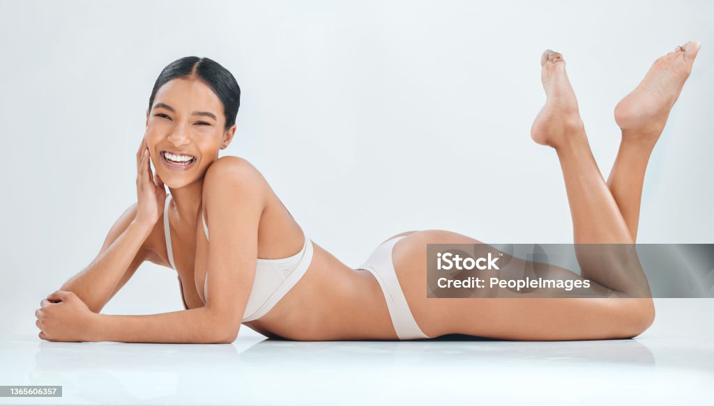 Full Length Shot Of A Young Woman Lying Down In The Studio And