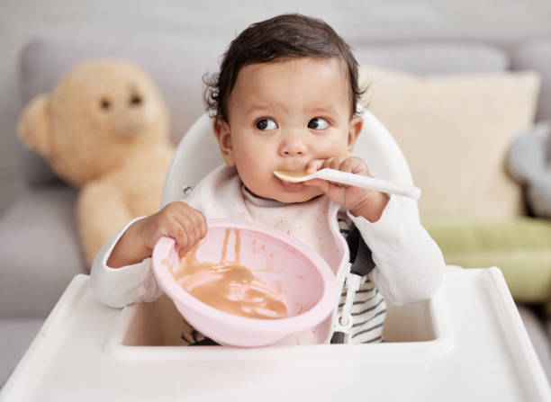 aufnahme eines babys, das zu hause eine mahlzeit isst - gegessen stock-fotos und bilder