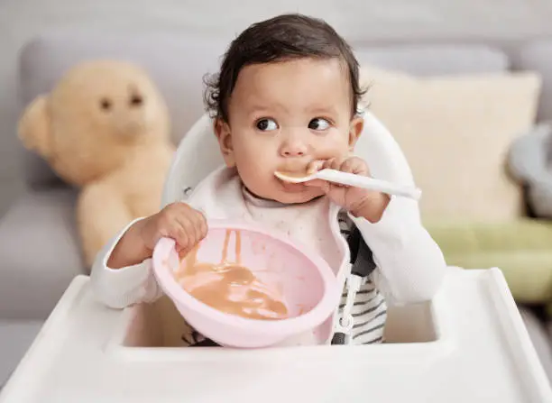 Photo of Shot of a baby eating a meal at home