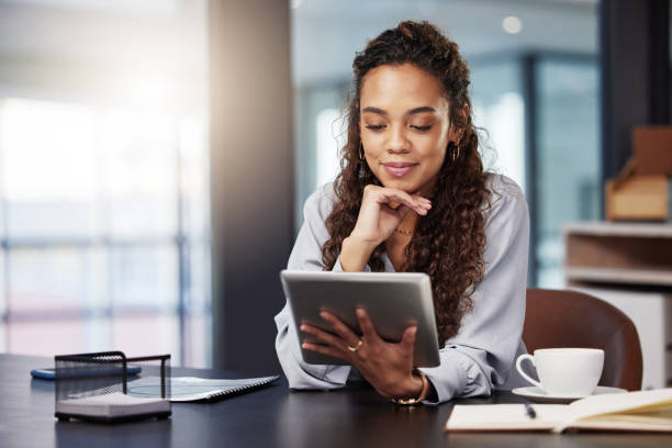 Shot of a young businesswoman using a digital tablet while at work Ready to read on the go one woman only stock pictures, royalty-free photos & images