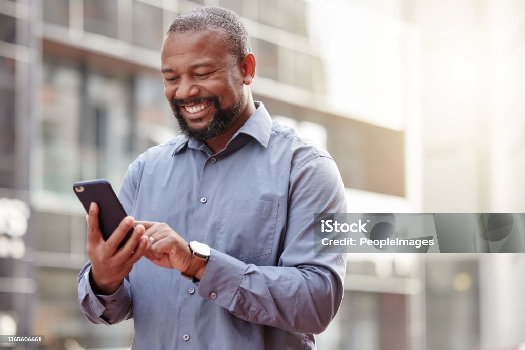 Shot of a businessman using his smartphone outside in the city Working no matter where I am Men Stock Photo