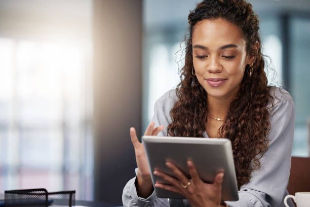 istock Shot of a young businesswoman using her digital tablet at work 1365606671