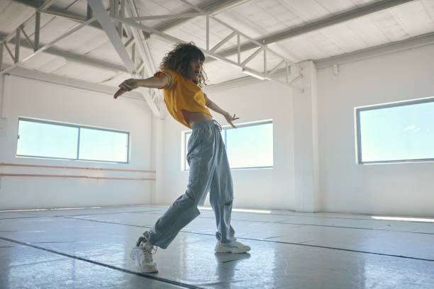 Full length shot of an attractive young female hip hop dancer practicing in her studio stock photo