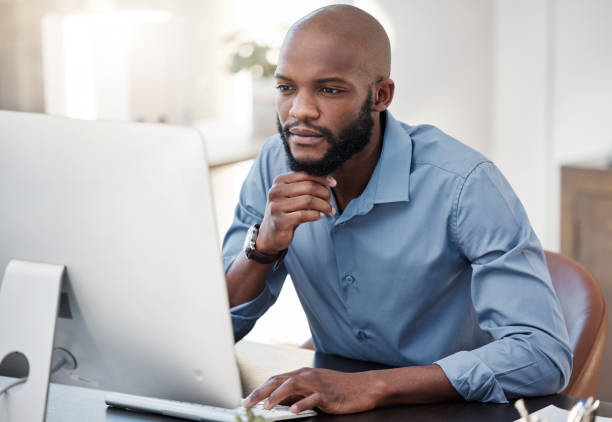 istock Cropped shot of a handsome young businessman looking thoughtful while working on his computer in the office 1365606967