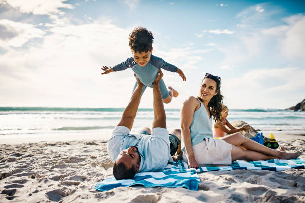 istock Shot of a man playing with his son on the beach 1365608657