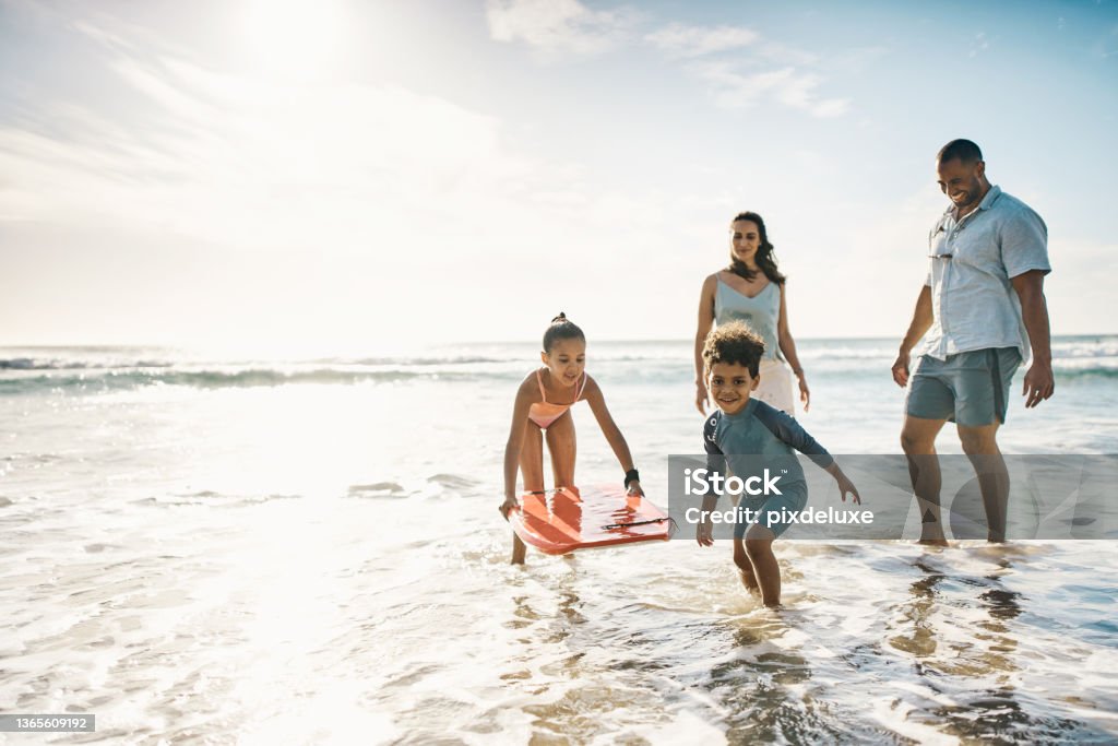 Shot of a young couple and their two kids spending the day at the beach We're having a great time Family Stock Photo