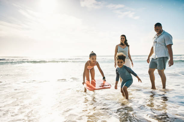 Shot of a young couple and their two kids spending the day at the beach stock photo
