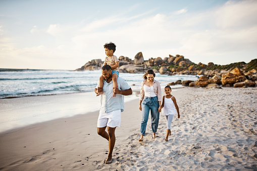 Foto de una joven pareja y sus dos hijos pasando el día en la playa photo