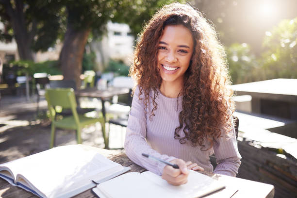 Shot of a young female student studying at a cafe