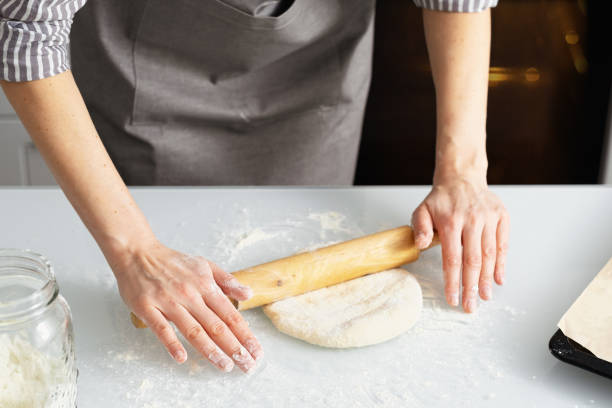 istock A woman in the kitchen rolls out dough. Yeast dough pastries. 1365614693