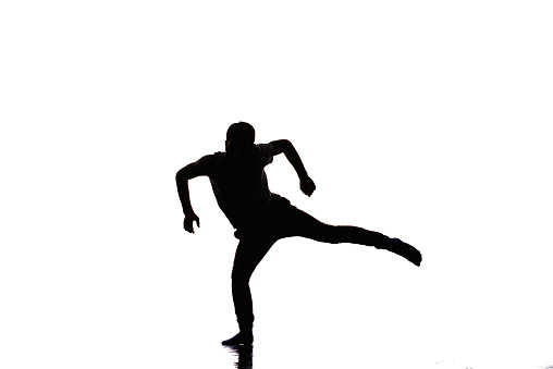 Young handsome dancer in motion is dancing in the studio