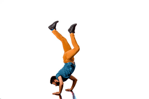 Guy standing on one hand on the edge upside down. Rooftop dangerous extreme sports.