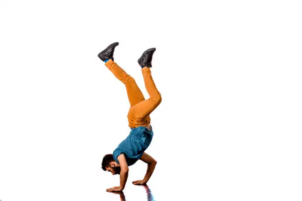 Young adult man doing handstand during street dance