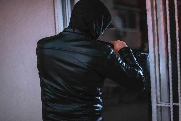 istock Male thief break the window with crowbar tool 1365618735