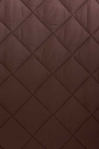 brown quilted down jacket close-up - fabric background