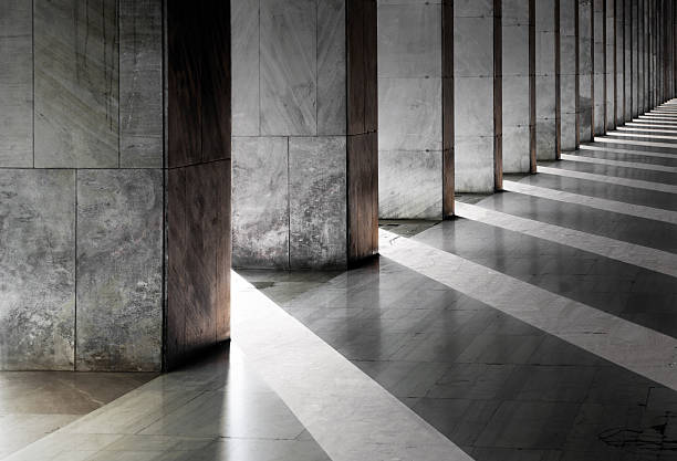 Columns and shadows over an empty hallway stock photo