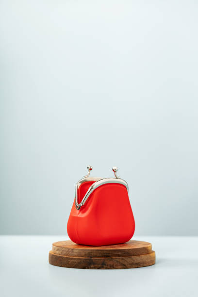 istock Open Red Coin Purse on wooden podium on blue background 1365626818