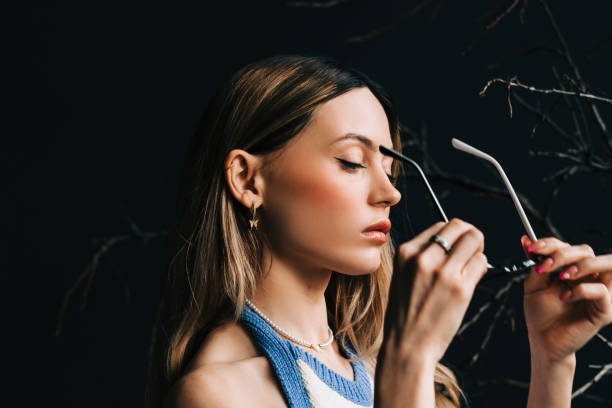 Young caucasian woman putting on eyeglasses.