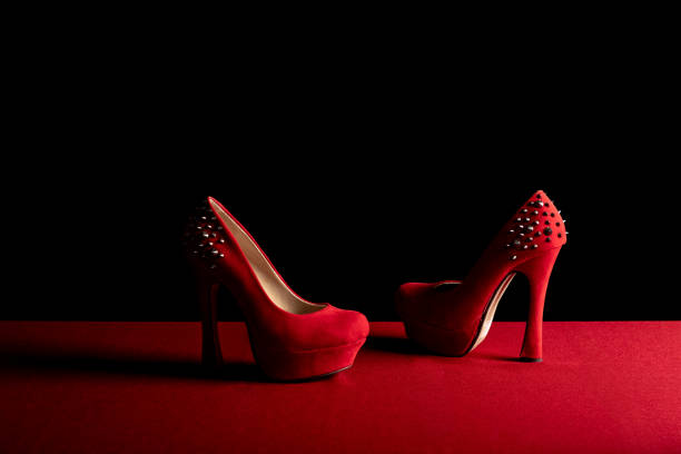 istock Sexy, red high heals with spikes, on a red an black background. 1365634624
