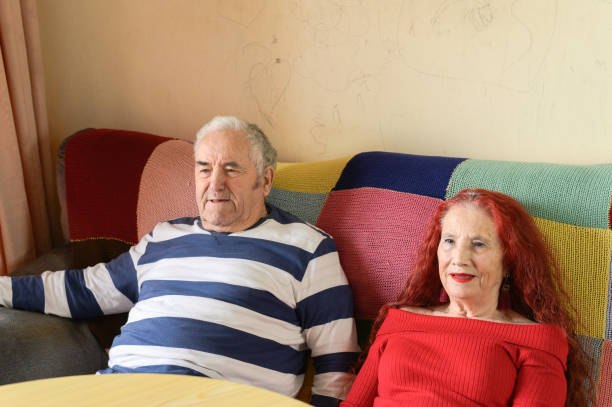 istock Cute old couple sitting on the sofa at home. 1365637854