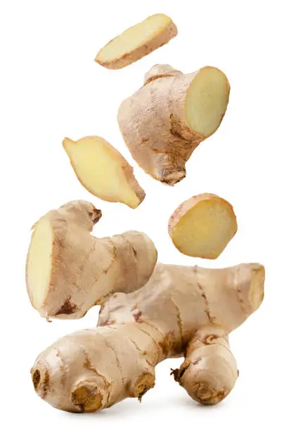 Photo of Pieces of ginger are falling on a white. Isolated