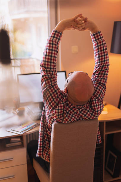 istock Freelance designer stretching out while working in home office 1365642503