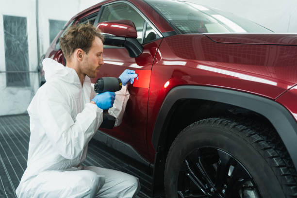 istock Professional auto painter matches car paint color with lamp and samples 1365643796