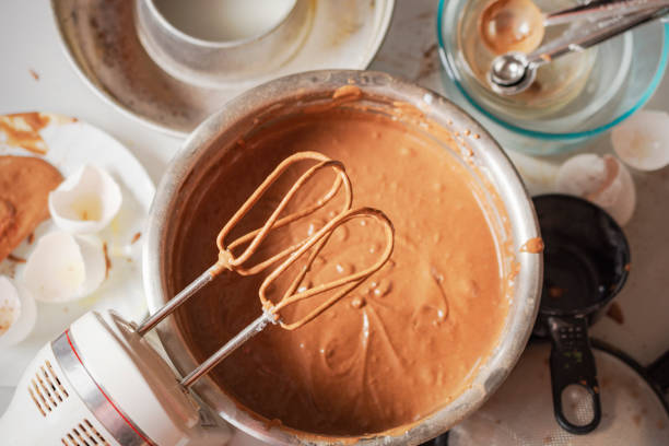 Making of a chocolate cake:  A fun overhead look at the mess created when making a chocolate cake. Making of a chocolate cake:  A fun overhead look at the mess created when making a chocolate cake.  Messy tools, bowls, and egg shells surround the chocolate batter. electric whisk stock pictures, royalty-free photos & images