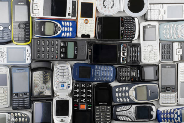 a lot of old used mobile phones with keyboards, various brands. many types and generations of mobile smartphone gadgets are in heap. editorial - sony imagens e fotografias de stock