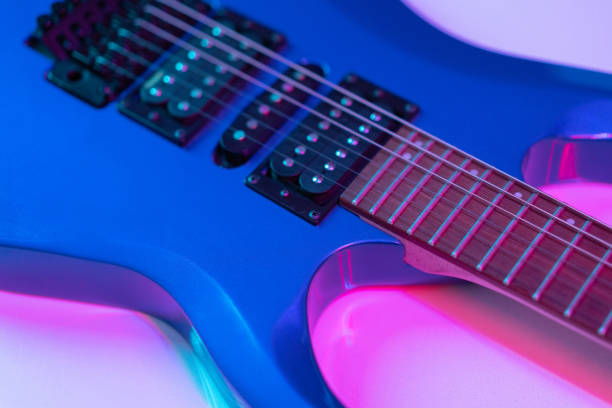 Still life with part of an electric guitar lighted neon light.