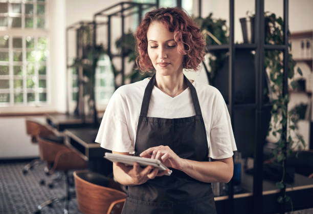 istock Shot of a hairstylist using a digital tablet at work 1365651513
