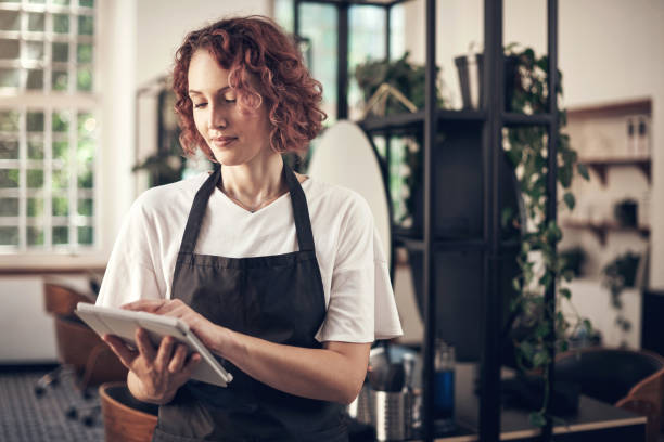 istock Shot of a hairstylist using a digital tablet at work 1365651518