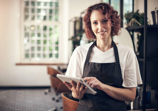 istock Shot of a hairstylist using a digital tablet at work 1365651683