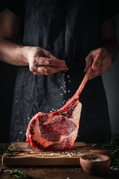 Photo of tomahawk steak in man’s hands