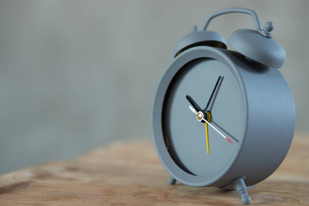 istock Vintage alarm clock on wooden table on grey background, copy space for text 1365657252