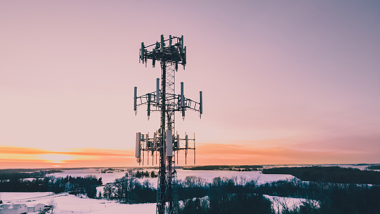 Sunsets with radio tower and snow covered land