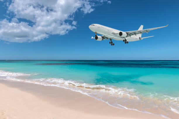 Airplane landing over beautiful beach. White airplane flying over turquoise colored sea and white sand beach, Maho Bay, Sint Maarten, Caribbean, Lesser Antilles. Travel and transportation concept. aircraft point of view stock pictures, royalty-free photos & images