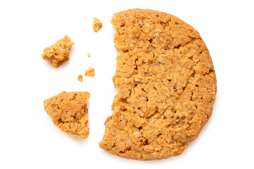 Broken stem ginger biscuit with crumbs isolated on white. Top view.