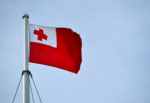 Nuku'alofa, Tongatapu island, Tonga: flag of the Kingdom of Tonga in the wind - red flag with a white canton containing a red cross.