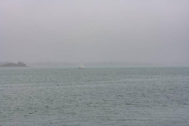 A sailboat in the mist in the Morbihan gulf, Brittany