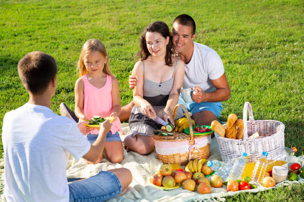 istock Happy parents with children enjoying picnic 1365663964