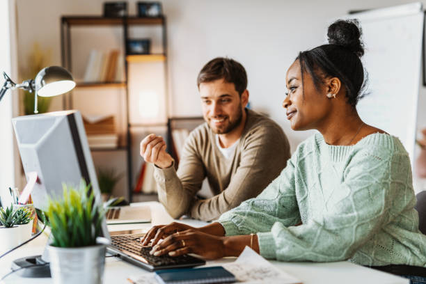 istock Multi ethnic group of entrepreneurs working in office after reopening 1365664197